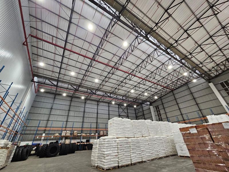 Spacious industrial warehouse featuring high-clearance steel truss roofing, fire sprinkler systems, efficient LED lighting, and durable concrete flooring suitable for large-scale storage operations.