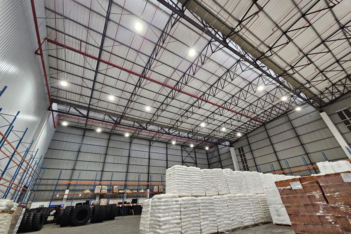 Spacious industrial warehouse featuring high-clearance steel truss roofing, fire sprinkler systems, efficient LED lighting, and durable concrete flooring suitable for large-scale storage operations.