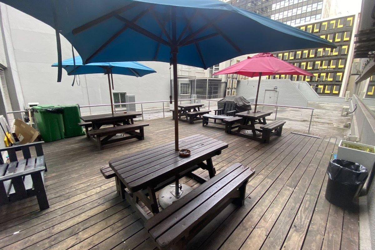 An outdoor commercial patio area featuring timber decking and metal safety railings, suitable for staff or client break-out space.