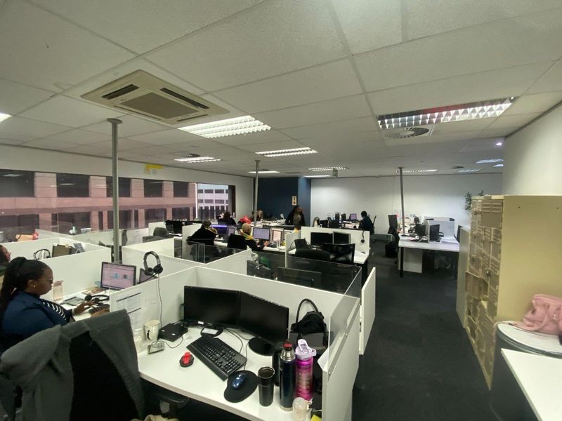 Open-plan commercial office space featuring suspended ceilings, integrated air conditioning, and modular workstation partitions.
