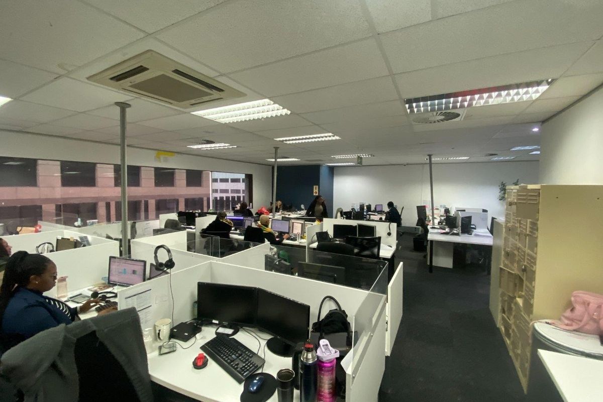 Open-plan commercial office space featuring suspended ceilings, integrated air conditioning, and modular workstation partitions.