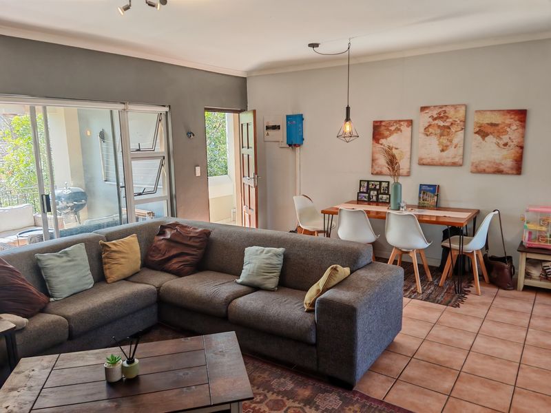 Open-plan living and dining area featuring tiled flooring, sliding glass doors to the patio, and integrated electrical infrastructure.