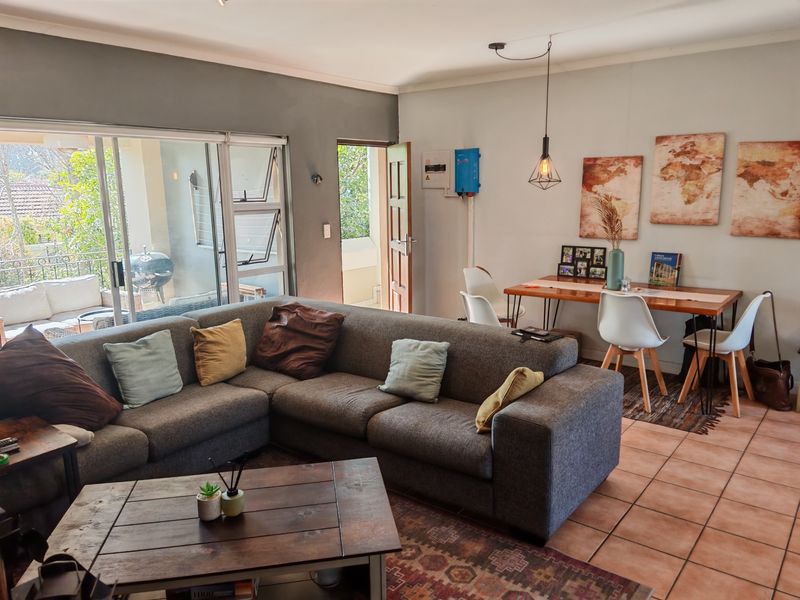 Open-plan living and dining area featuring tiled floors, sliding doors to a patio, and integrated electrical infrastructure including an inverter system.