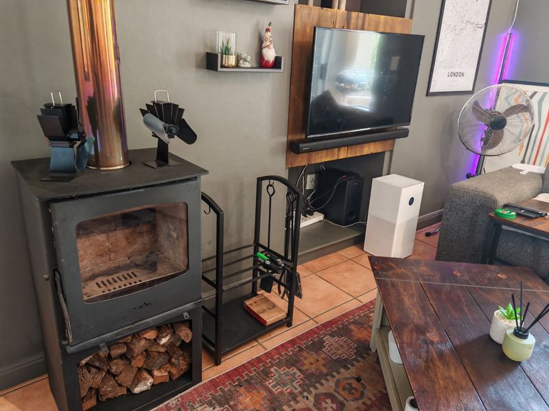 Living room featuring a freestanding wood-burning stove with a flue pipe and tiled flooring.