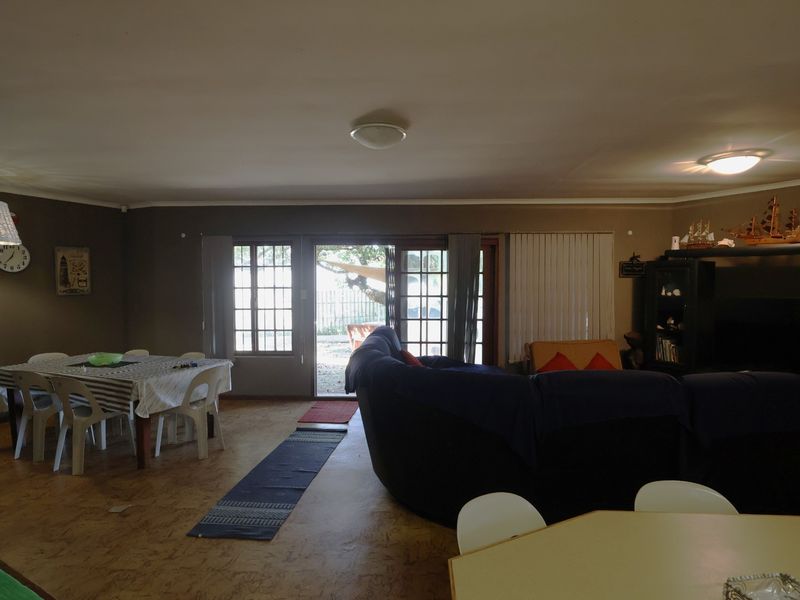 Spacious open-plan living and dining area featuring cork flooring and direct access to the outdoor space through sliding glass doors.