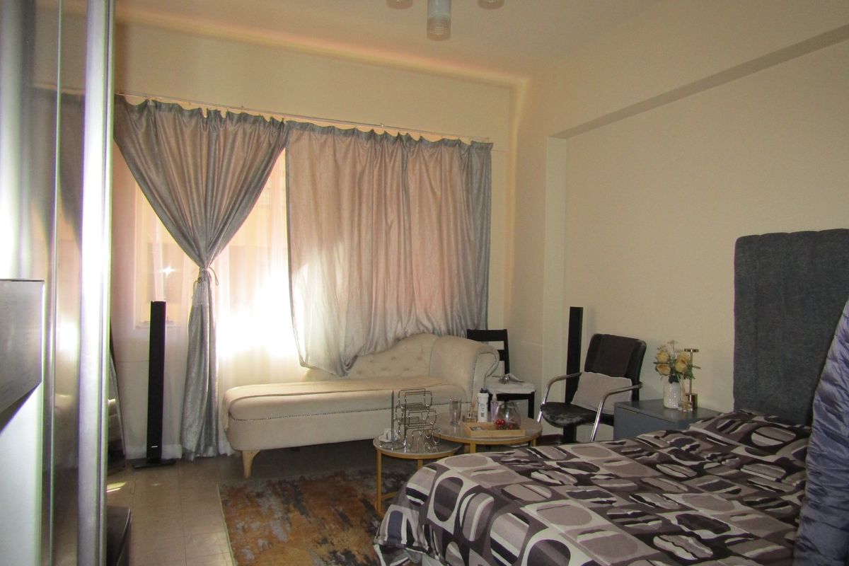 A bedroom featuring tiled flooring and a central ceiling light fixture, providing a functional living space.