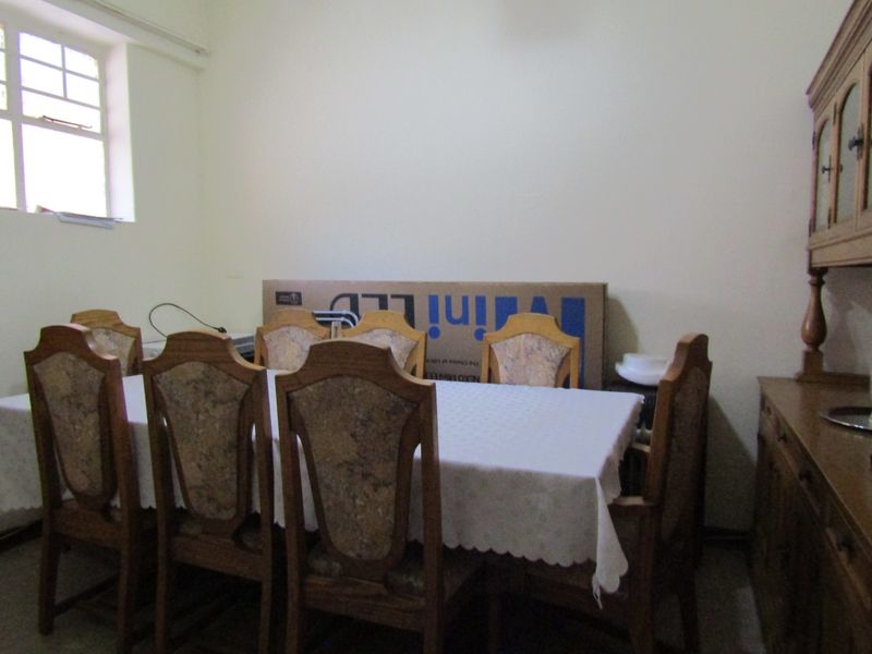 A dining room featuring a multi-pane window and plain wall finishes, providing a functional space for family meals.