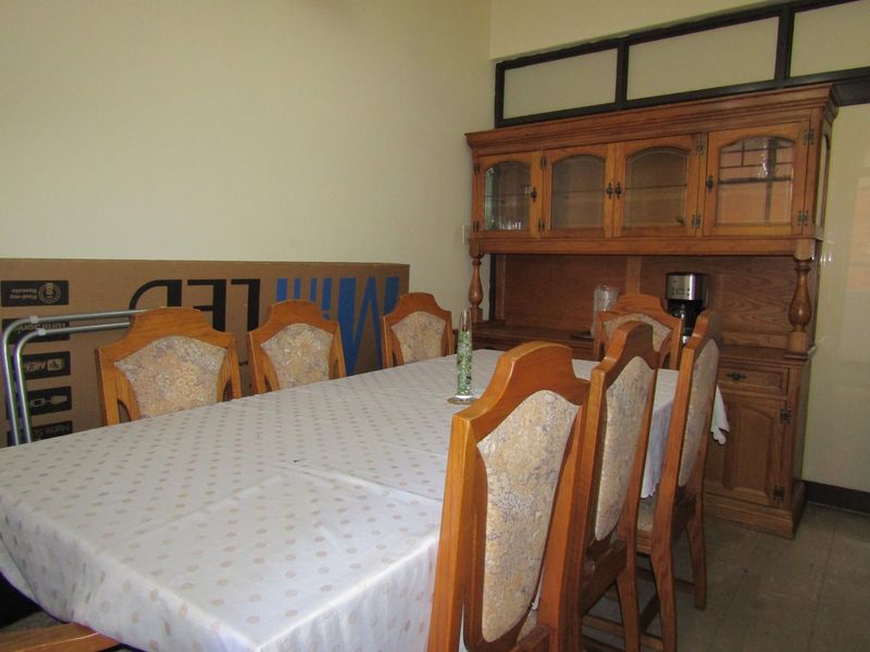 A dining room featuring a traditional built-in wooden hutch and tiled flooring, offering a functional space for family meals.