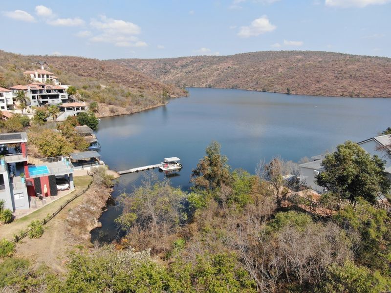 Aerial view of the waterfront property featuring a private jetty and scenic lake views within a residential estate setting.
