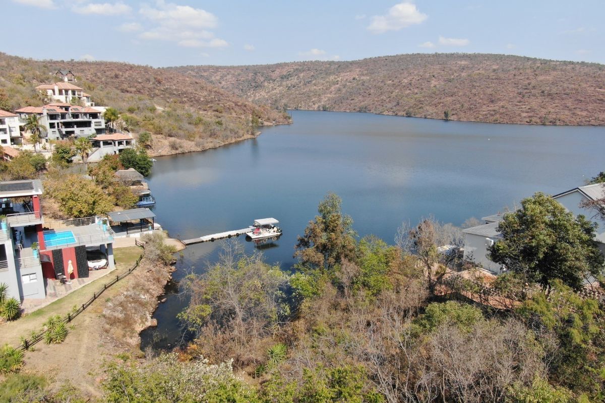 Aerial view of the waterfront property featuring a private jetty and scenic lake views within a residential estate setting.