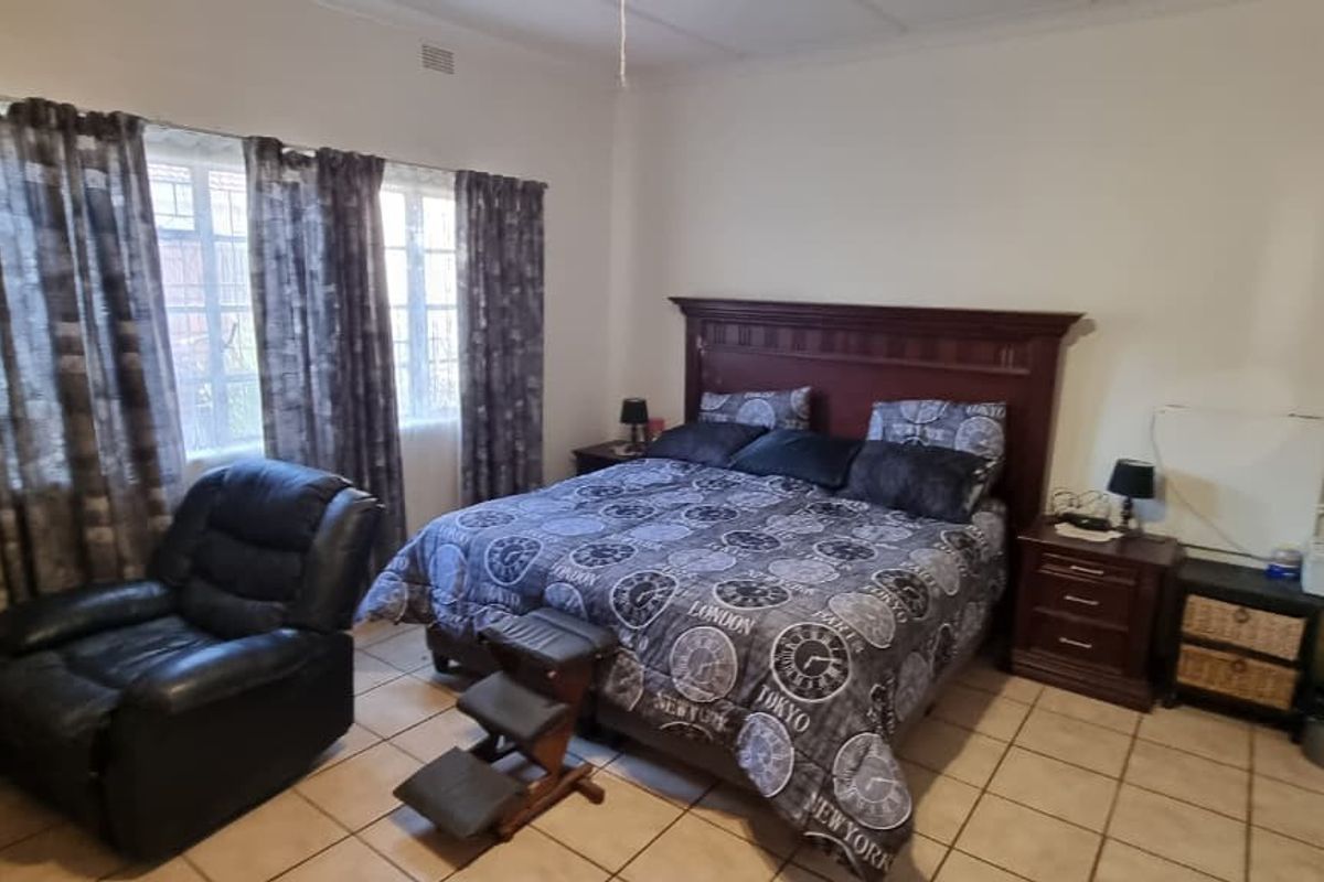 A bedroom featuring tiled flooring and a ceiling fan, offering a functional space with standard finishes.