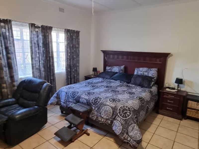 A bedroom featuring tiled flooring and a ceiling fan, offering a functional space with standard finishes.