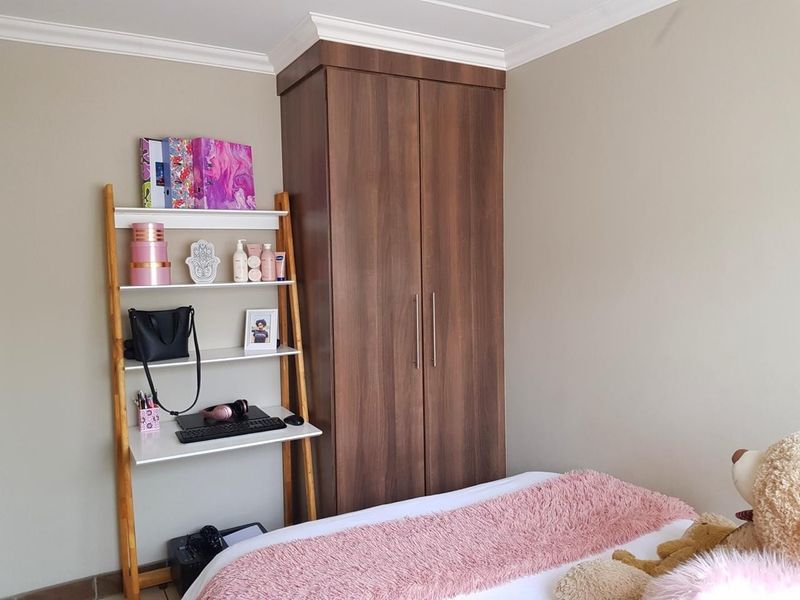 A bedroom featuring a dark wood built-in wardrobe and decorative crown molding.