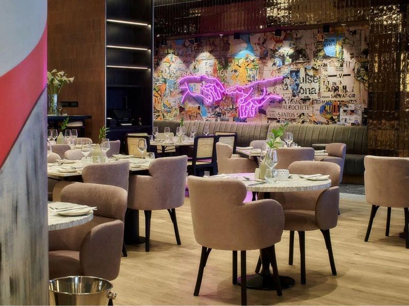 A stylishly designed clubhouse or dining area featuring modern banquette seating, decorative wall art, and high-quality finishes throughout the space.