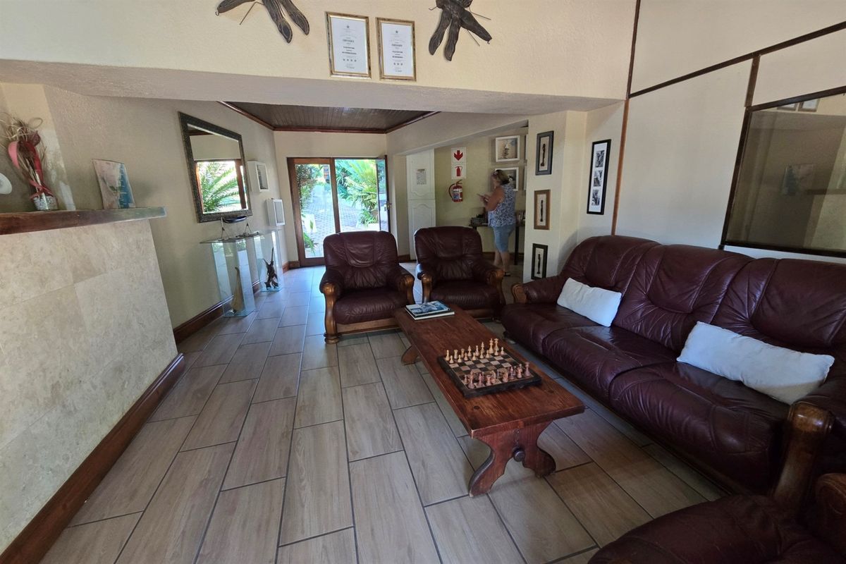 Spacious living area featuring tiled flooring, timber ceiling accents, and direct access to the outdoor area through a sliding glass door.