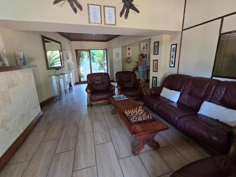 Spacious living area featuring tiled flooring, timber ceiling accents, and direct access to the outdoor area through a sliding glass door.