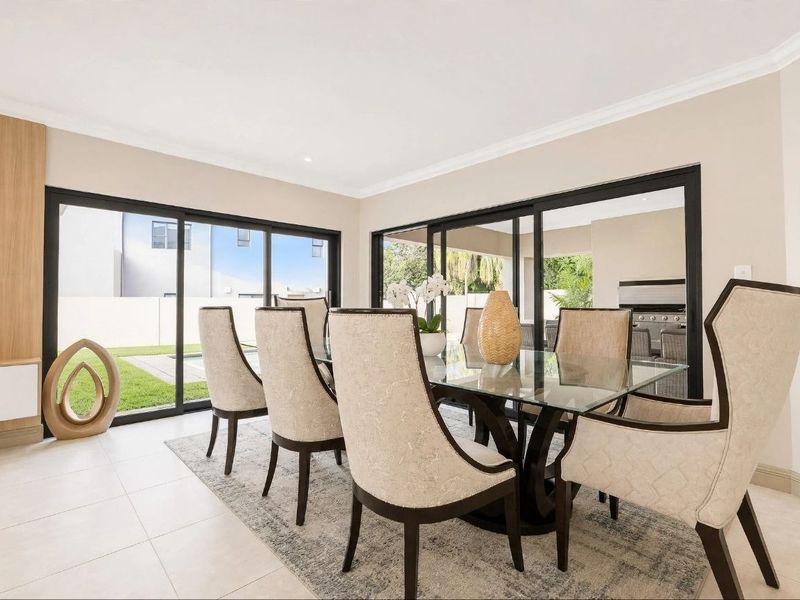 Bright dining room featuring large sliding glass doors that provide seamless access to the outdoor patio and garden area.