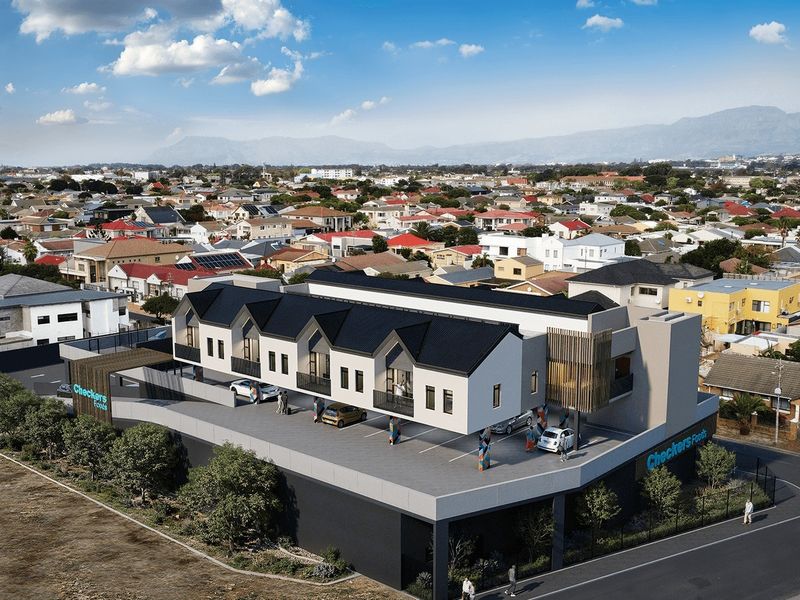 Aerial view of a modern multi-level residential and commercial development featuring a pitched roof design and integrated parking facilities.
