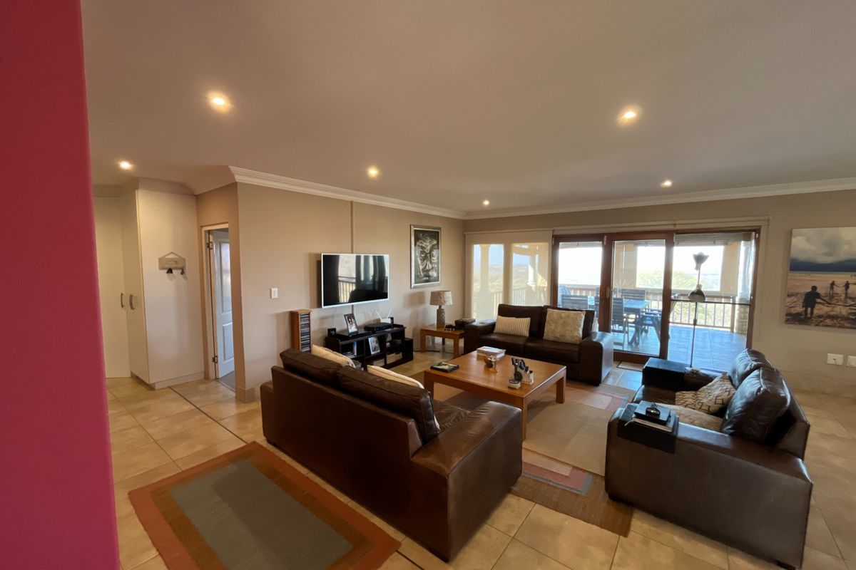 Spacious living room featuring tiled flooring, recessed lighting, and large sliding glass doors that provide access to an outdoor patio area.