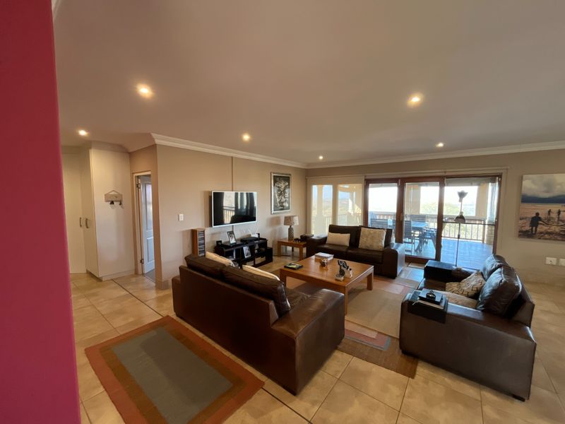 Spacious living room featuring tiled flooring, recessed lighting, and large sliding glass doors that provide access to an outdoor patio area.