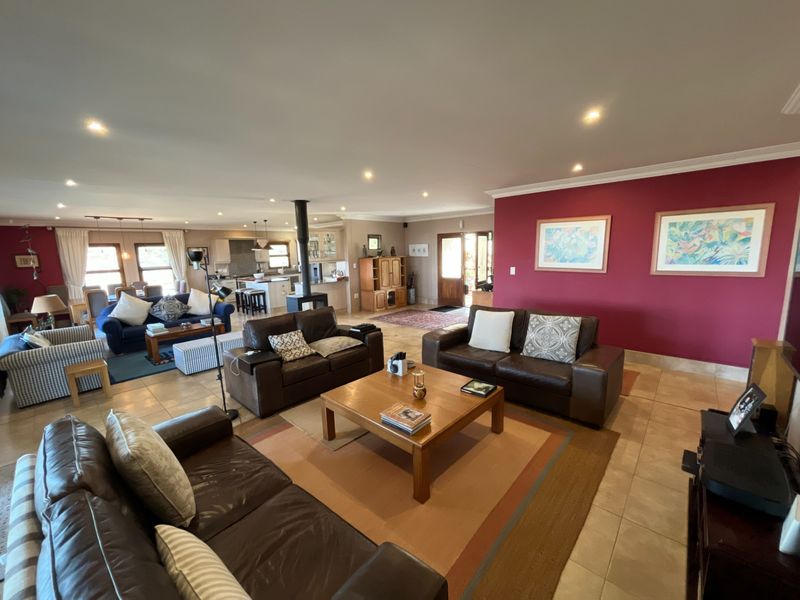 Spacious open-plan living area featuring a central fireplace, tiled flooring, recessed lighting, and a seamless flow into the kitchen and dining space.