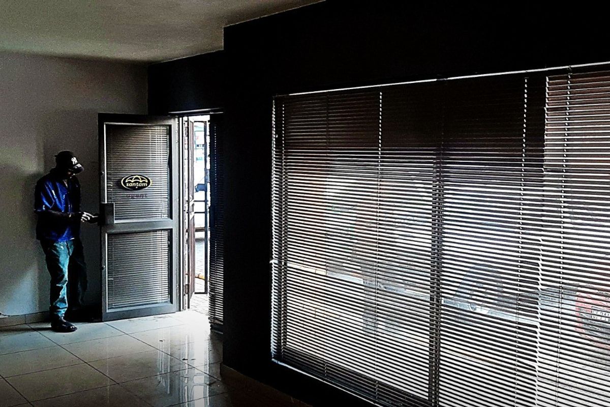 An empty commercial entry area featuring tiled flooring, large windows with venetian blinds, and an aluminium framed glass entrance door.