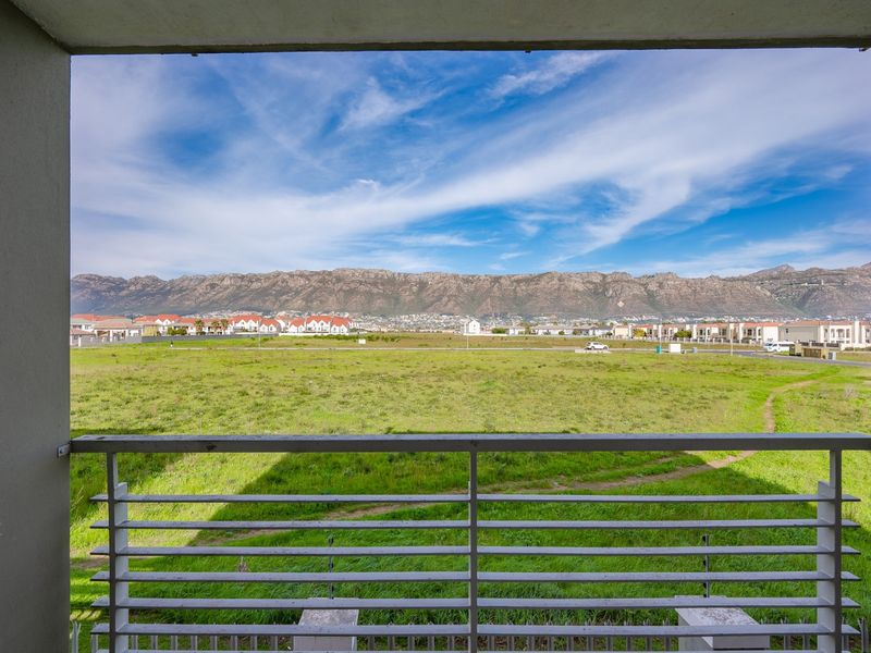 A balcony featuring a metal balustrade with expansive, unobstructed views of the surrounding landscape and distant mountains.