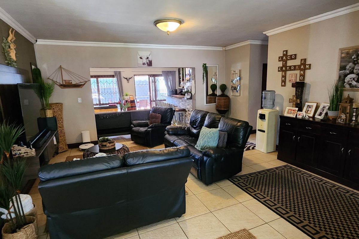 Spacious living room featuring tiled flooring and direct access to an outdoor patio area through sliding glass doors.