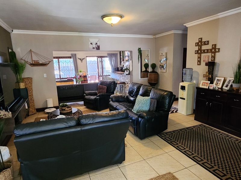 Spacious living room featuring tiled flooring and direct access to an outdoor patio area through sliding glass doors.
