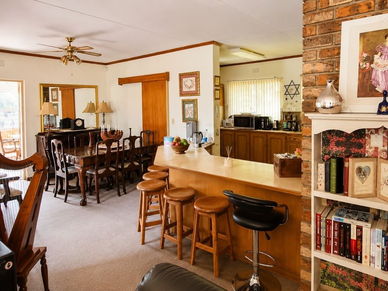 Open plan living and dining area featuring a breakfast bar, exposed brick accents, and direct access to an outdoor patio space.