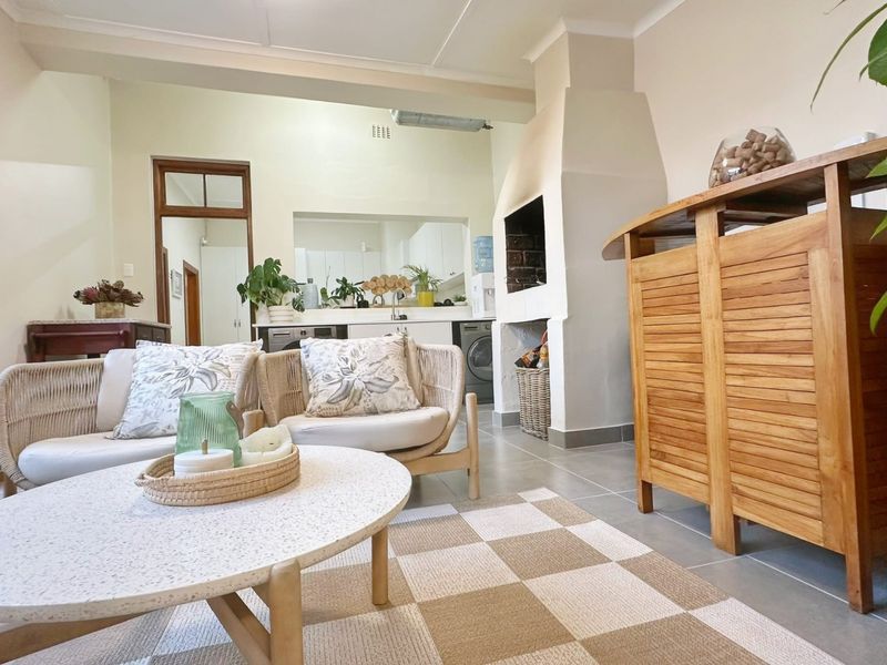Open-plan living area featuring a built-in fireplace, tiled flooring, and a view through to the kitchen space.