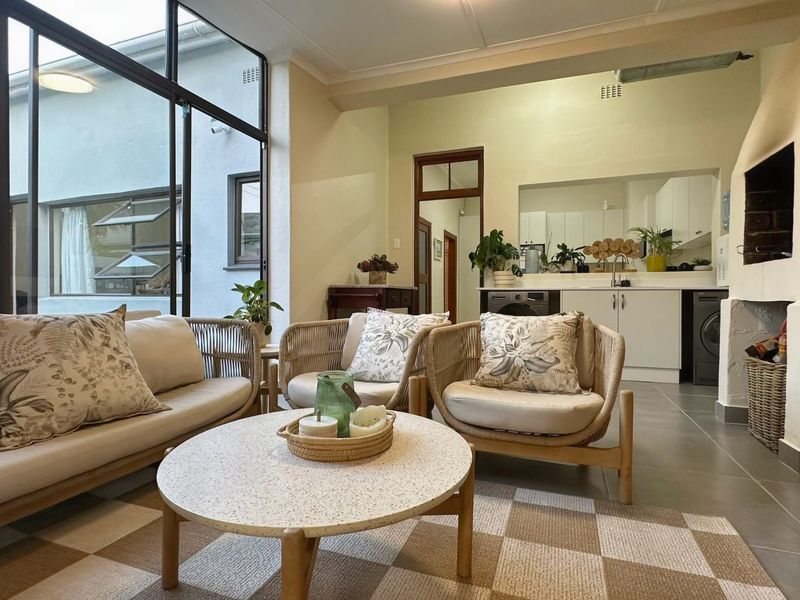 An open-plan living area featuring a built-in fireplace, tiled floors, and large glass doors that provide ample natural light and access to the exterior.