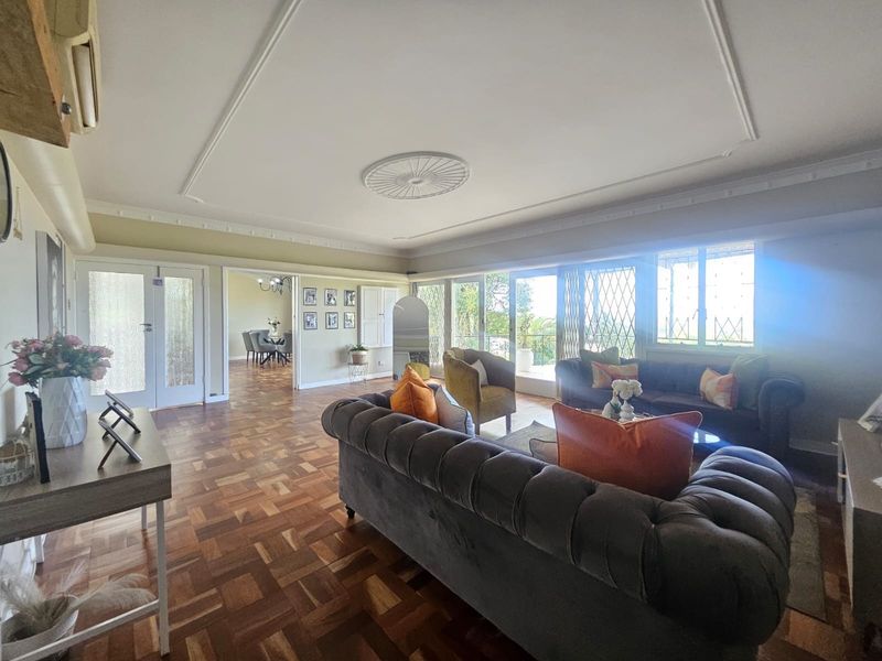 Spacious living room featuring classic parquet flooring, decorative ceiling details, and large sliding doors that provide ample natural light and access to the exterior.