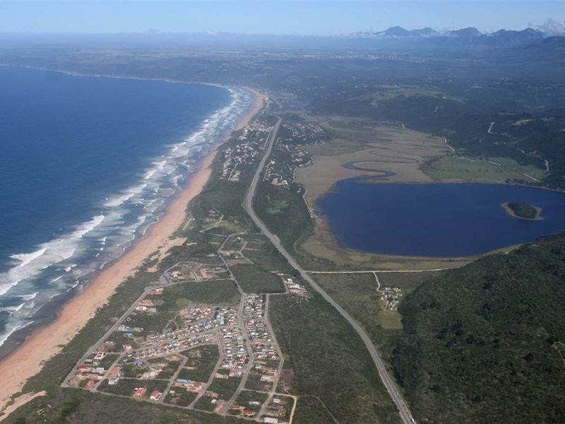 An aerial view of the coastal residential area, showcasing the proximity to the ocean, lake, and surrounding natural landscape.