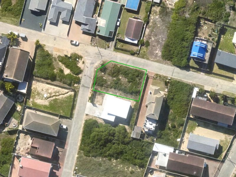 An aerial view of a vacant residential plot in a developed neighborhood, showing the property boundaries and surrounding street layout.