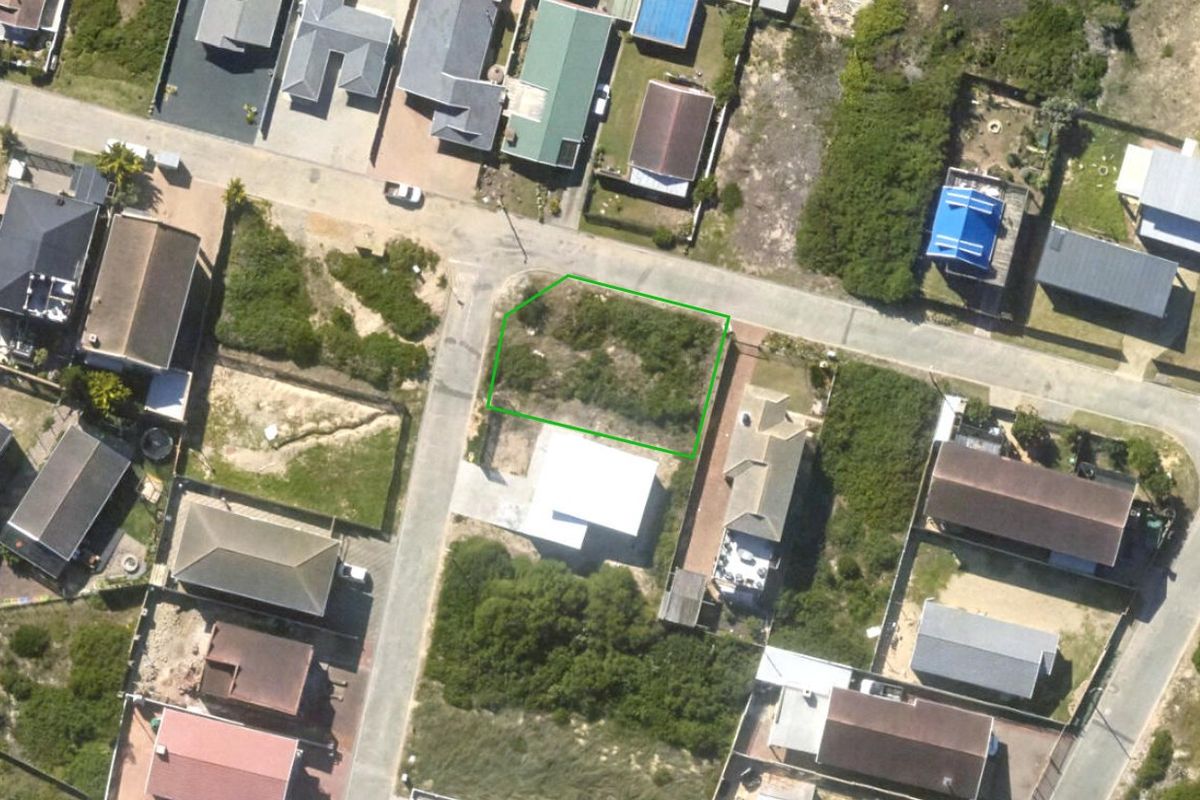 An aerial view of a vacant residential plot in a developed neighborhood, showing the property boundaries and surrounding street layout.