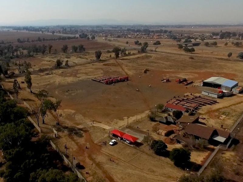 Aerial view of an industrial property featuring a warehouse, expansive yard space, and perimeter fencing, suitable for logistics or storage operations.