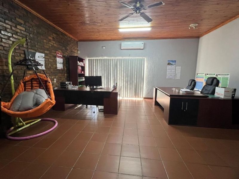 Spacious office area featuring exposed brick wall, timber ceiling, ceramic tiled flooring, and integrated air conditioning.