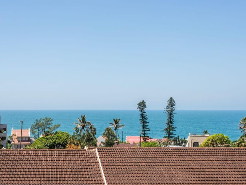 A clear, elevated view of the ocean and surrounding coastal neighborhood, captured from an upper-level vantage point.