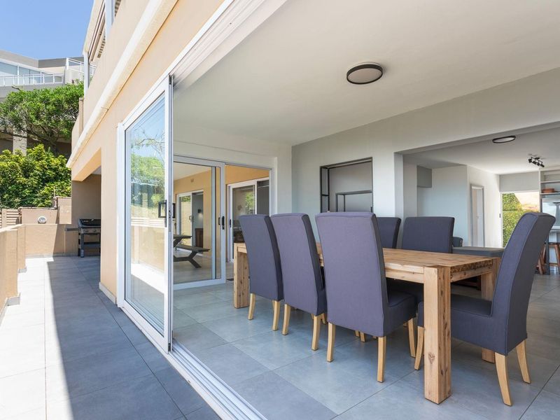 A spacious covered patio featuring large sliding glass doors that provide seamless indoor-outdoor flow, perfect for entertaining.
