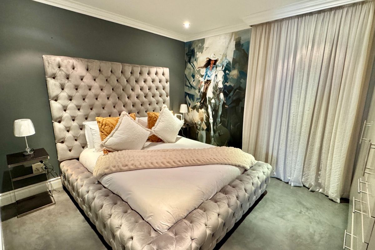 A well-appointed bedroom featuring modern concrete flooring, crown molding, recessed lighting, and a built-in wardrobe with a contemporary aesthetic.