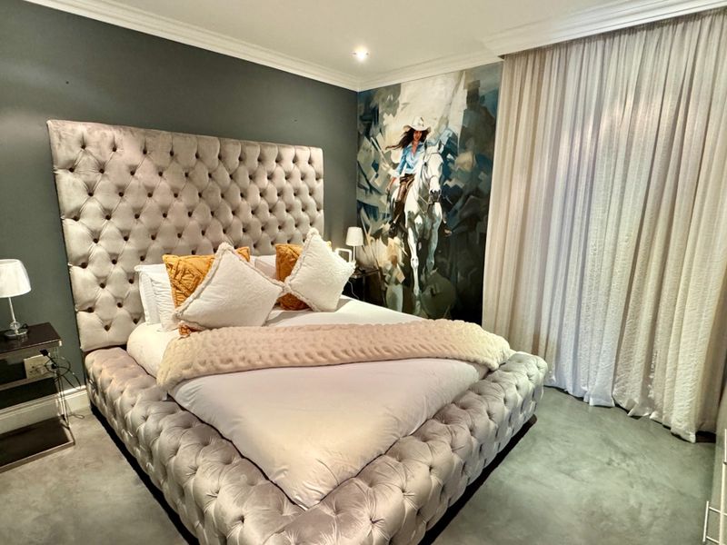 A well-appointed bedroom featuring modern concrete flooring, crown molding, recessed lighting, and a built-in wardrobe with a contemporary aesthetic.