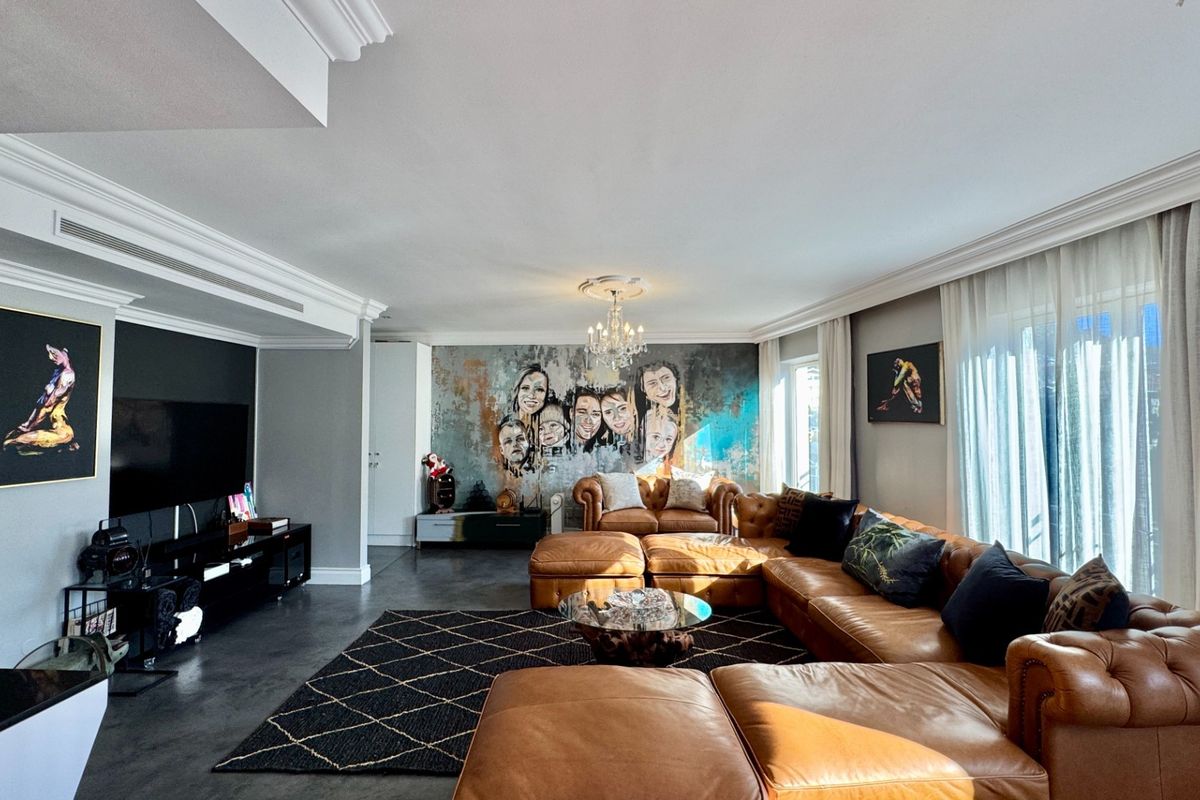 Spacious and well-appointed living room featuring elegant crown molding, recessed lighting, ducted air conditioning, and large format floor tiles.
