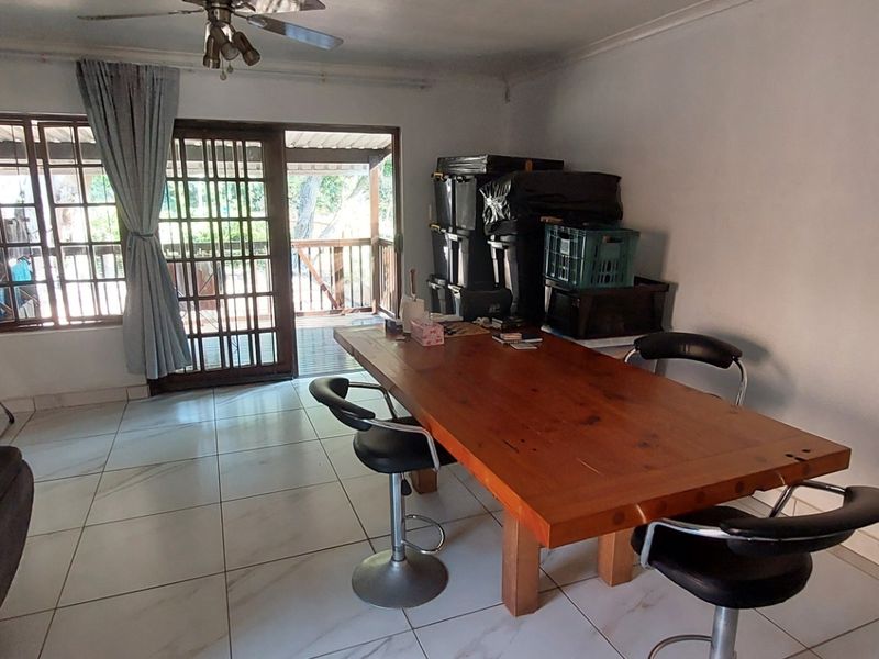 Dining area featuring tiled flooring, a ceiling fan, and sliding glass door access to an outdoor patio space.
