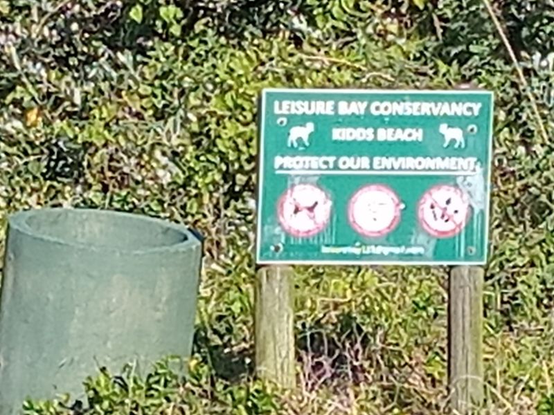 A sign for the Leisure Bay Conservancy located in a natural outdoor setting.