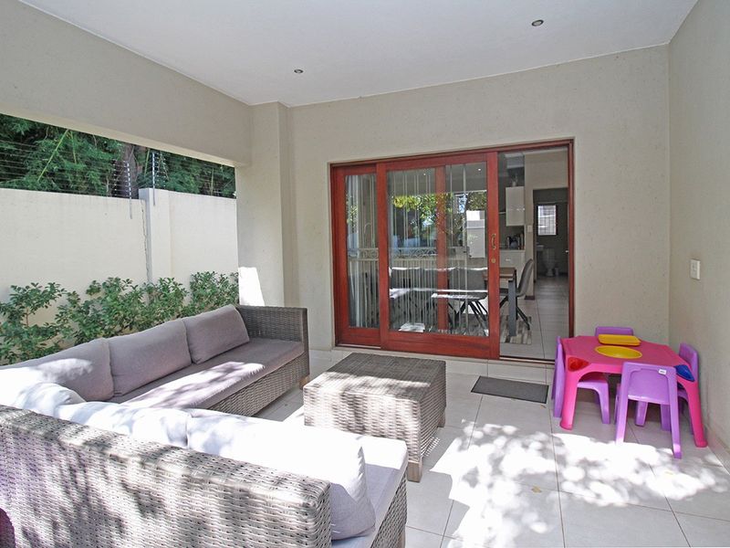 A covered patio area featuring tiled flooring, recessed lighting, and sliding glass doors providing seamless access to the interior living space.
