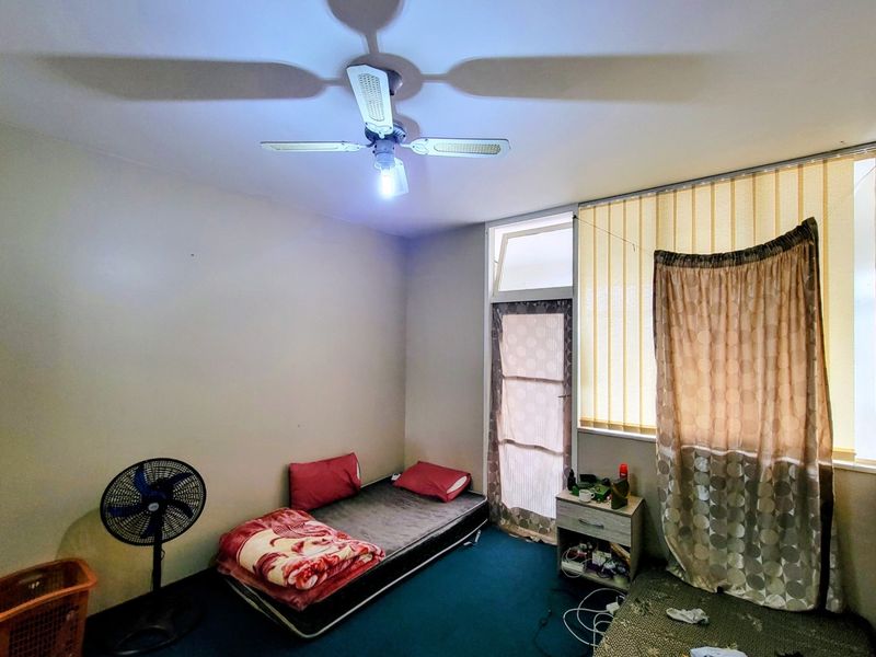 A bedroom featuring a ceiling fan, vertical blinds, and a glass door leading to an outdoor area.
