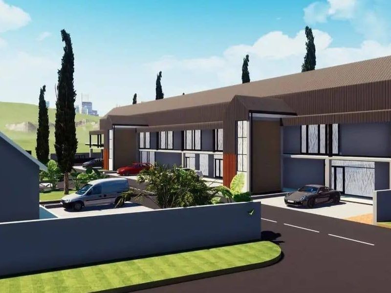 A 3D architectural rendering of a modern residential development featuring a multi-unit building with a pitched roof and paved driveway access.