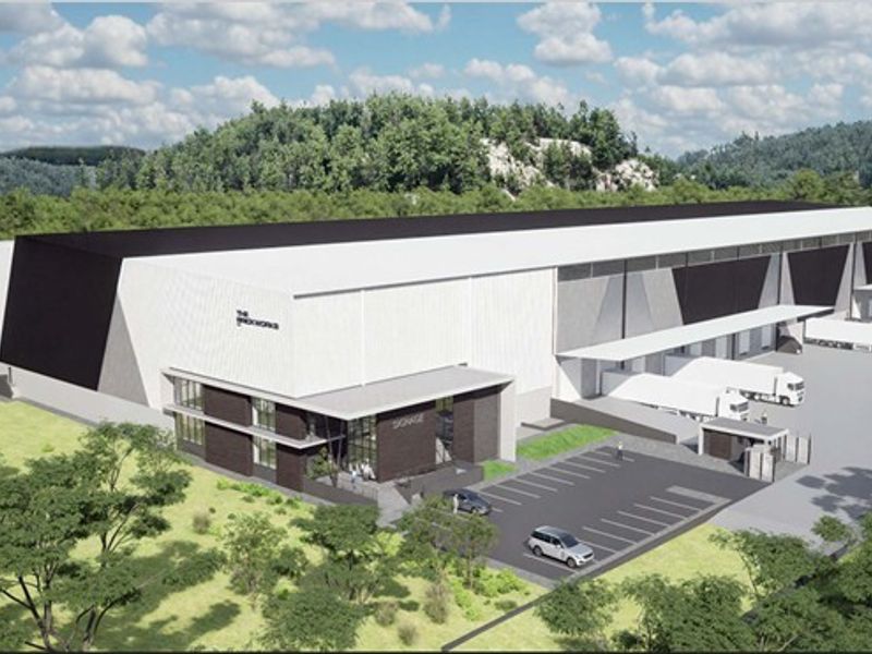 Aerial perspective of a modern industrial warehouse facility featuring multiple loading docks, dedicated parking, and a secure entrance gatehouse.