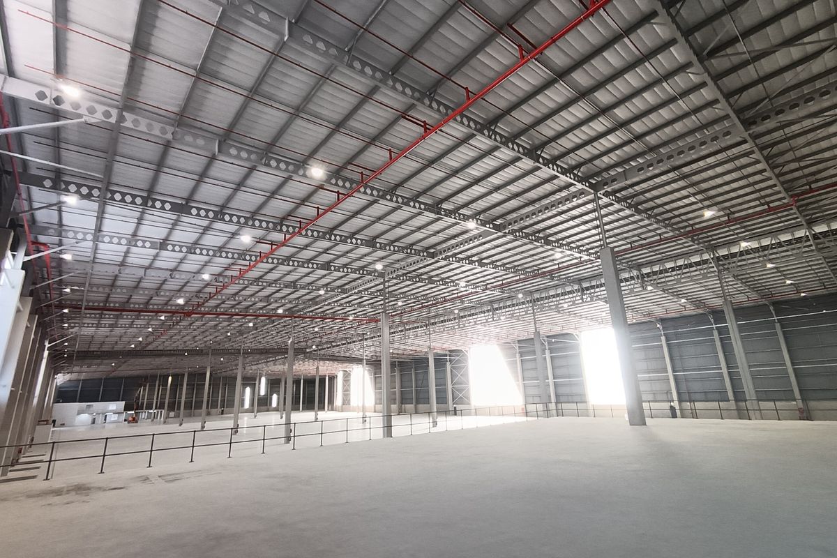 Spacious industrial warehouse featuring a high-clearance steel portal frame, integrated fire sprinkler system, and polished concrete flooring.